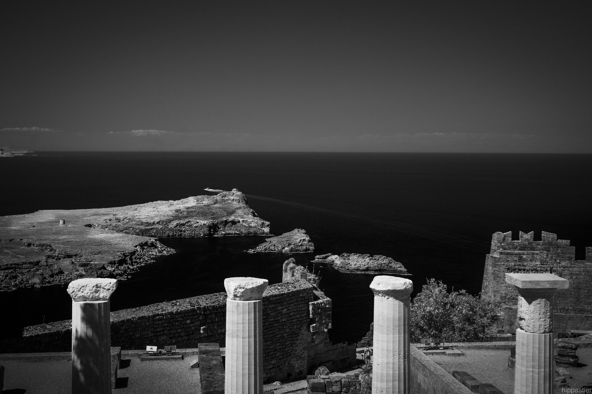 Ancient columns overlooking a dark sea and rocky coastline, black and white infrared, Acropolis of Lindos, Rhodes