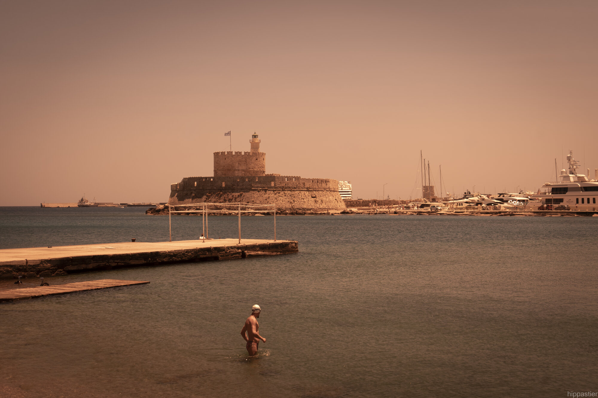 Fort of Agios Nikolaos at the harbour entrance with a swimmer in the foreground, full-spectrum photograph, Rhodes
